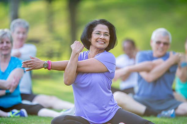 istock Fitness Class Outdoors Featuring Older Adults Stretching Together in a Park 2222620557