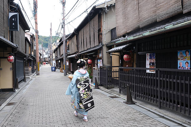 Kyoto - Japan. June 15, 2025. A geisha dressed in traditional dress walking through the quiet streets of Gion, Kyoto.