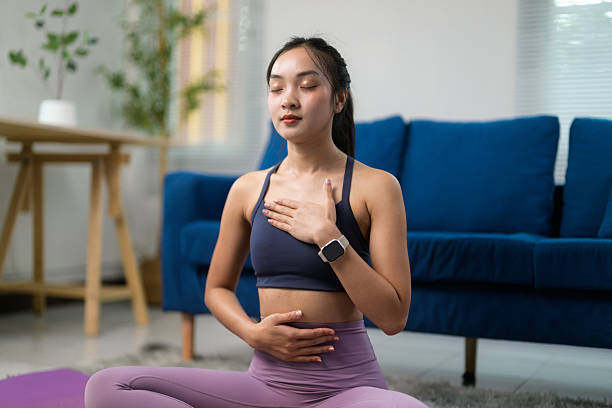 istock Asian woman practicing yoga and meditating at home, embracing relaxation while enjoying a moment of peace and tranquility 2222624920