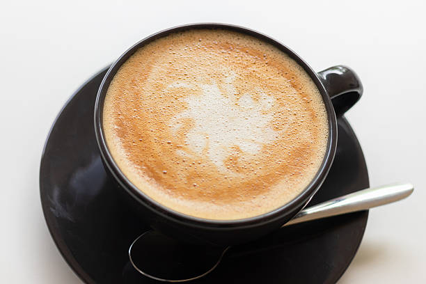istock Hot coffee with milk in a black cup on white table. 2222631206