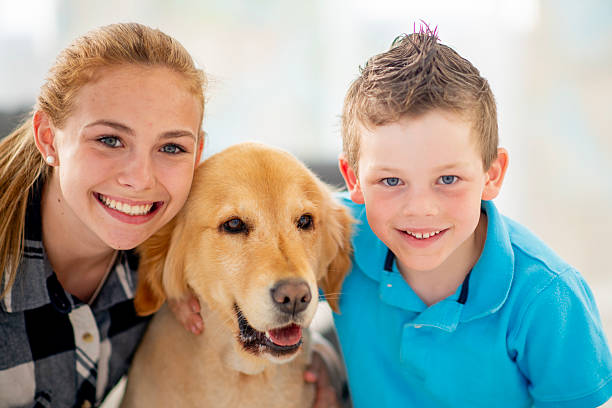 istock Happy Children Posing with Golden Retriever in Bright Indoor Setting 2222631604