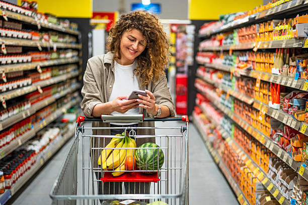 istock Woman using smartphone while shopping in supermarket 2222632423