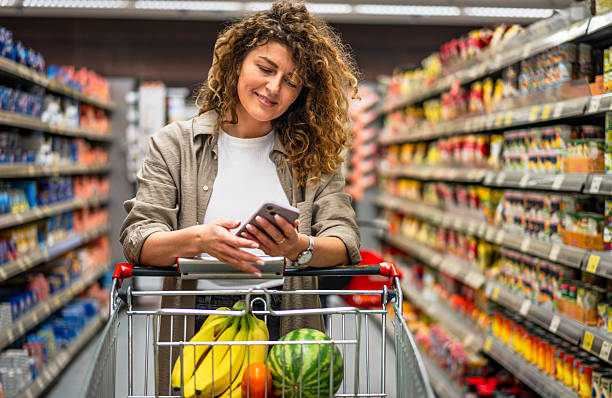 istock Woman using smartphone while shopping groceries in supermarket 2222632687
