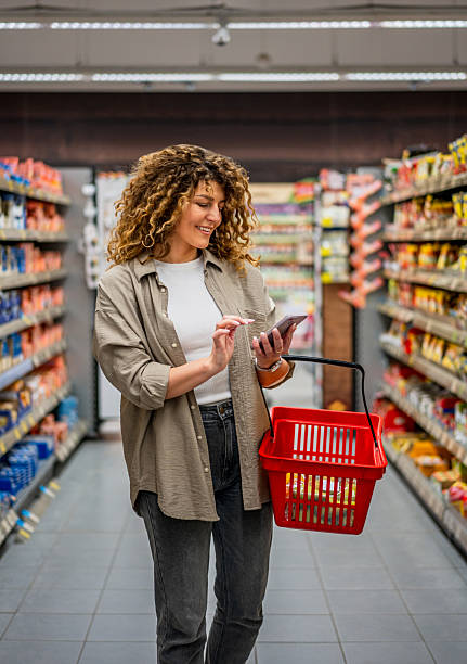 istock Woman using smartphone while shopping in supermarket 2222632927
