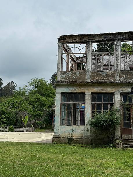 istock Old, abandoned two-story building with broken windows and peeling paint. An empty pool is visible nearby. Suitable for architecture, history, tourism, and media. 2222633224