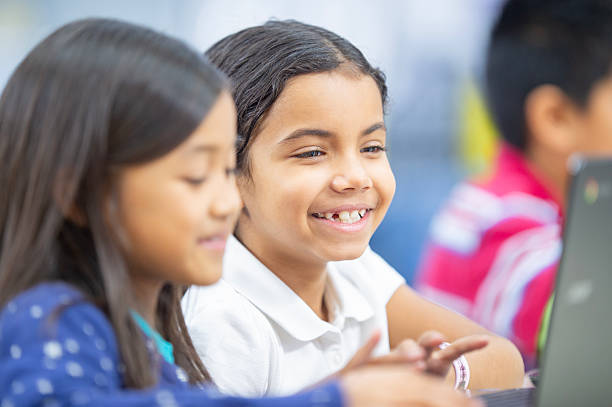 istock Young Students Smiling and Collaborating in a Classroom with Laptops 2222633519