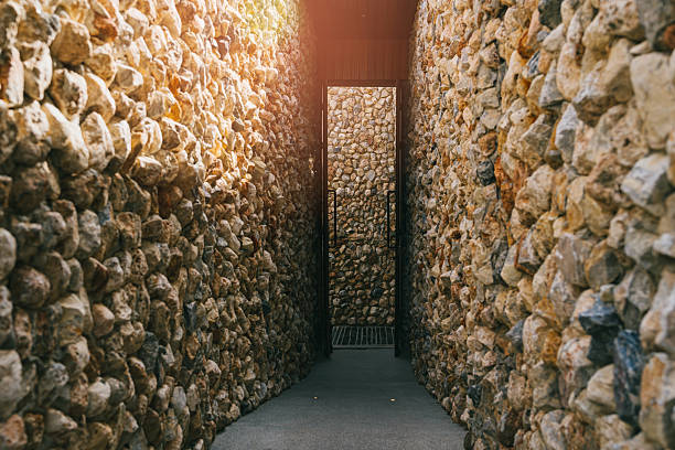 Serene Pathway Between Stone Walls Leading to Bright Light in a Narrow Alleyway.