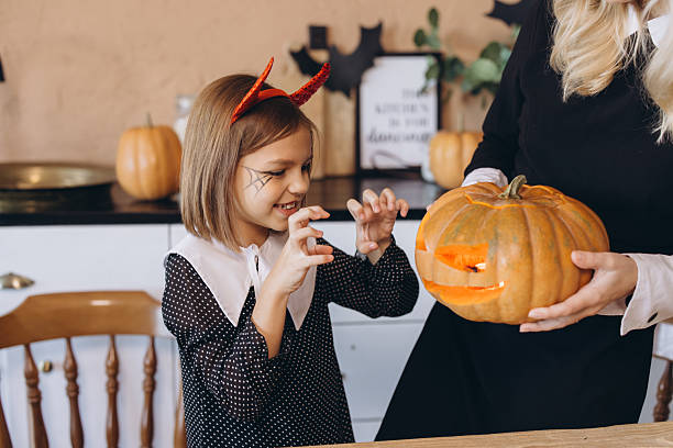 istock Mother and daughter preparing a jack-o'-lantern for Halloween 2222638384