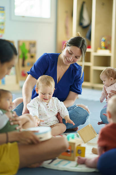 istock Mother and Babies Bonding During a Playgroup Activity in a Colorful Classroom 2222638844