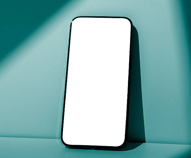 istock Smartphone mockup closeup. Black mobile device with screen leaning against blue mint colored pastel 2222639271