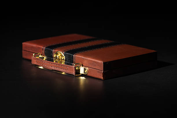 Dominoes, luxurious box with beautiful white domino pieces on black surface, selective focus.