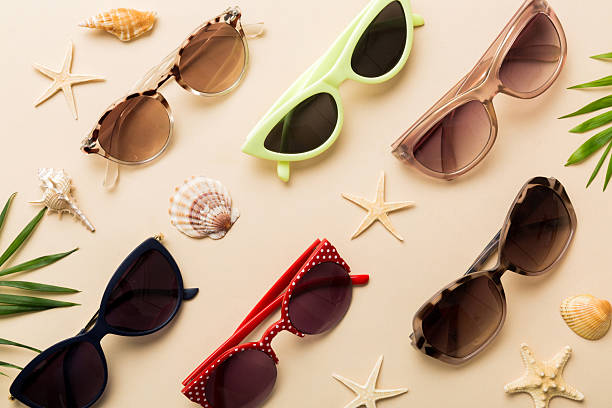 sunglasses with seashell lying on table background. Sunglasses on summer background. Top view flat lay with copy space for text.
