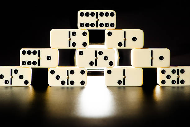 istock Dominoes, beautiful white domino pieces carefully placed on black surface, selective focus. 2222642651
