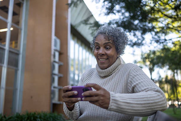 istock Middle-aged black woman playing with her smartphone on a park bench 2222648465