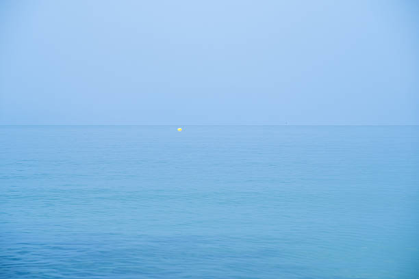 This tranquil image captures the serene beauty of a calm ocean with a faint horizon line, evoking a sense of peace, solitude, and vastness in a minimalist setting.