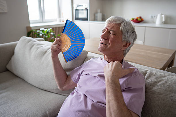 istock Distressed older male struggling with unbearable heat, using fan to relieve suffocation and nausea 2222656848