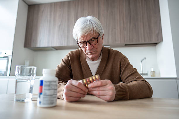 istock Sad lonely elderly man taking multiple medications with water, aging chronic health issues 2222659898