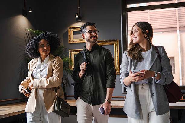 istock Three young professionals are walking and talking together in their modern office, enjoying a friendly and productive work environment 2222660056