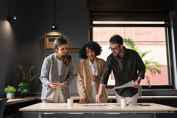 istock Business team analyzing paperwork, working together near glass windows in contemporary workspace, sharing innovative solutions 2222660211