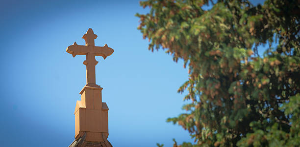 A southwestern style cross atop a steeple in Western USA.