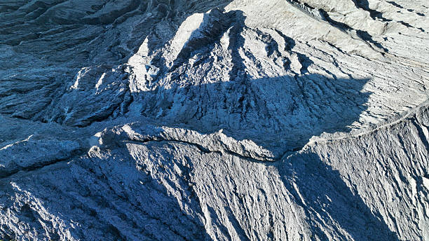 istock Aerial view unveils the intricate patterns carved into the volcano slopes. Shadows and sunlight highlight the dynamic surface, offering a glimpse into the heart of geological activity 2222677626