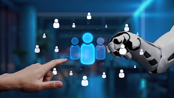 istock Human and Robot Interaction with Abstract User Icons in a Modern Office Environment, Symbolizing Artificial Intelligence and Technology Integration. Auvana 2222678884