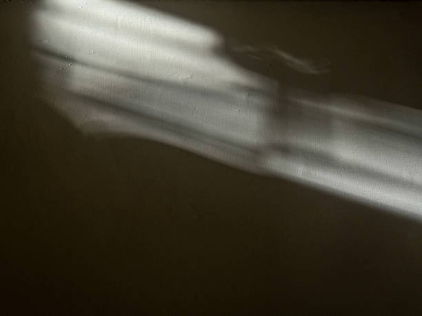 istock A shadow of a person is cast on a wall 2222680622