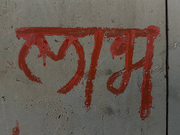 The word LAM is written in red on a gray wall. The red paint gives the word a sense of anger or frustration