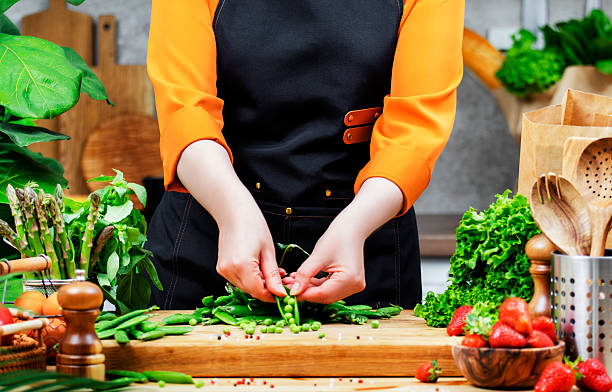 istock Chef preparing fresh vegetables for a healthy vegan dish in a vibrant kitchen filled with greenery 2222688609