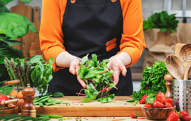 istock dedicated chef showcases a variety of fresh vegetables, highlighting a commitment to healthy vegan cooking in her inviting kitchen space. 2222688617