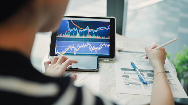 istock modern investor analyzing real-time financial data on laptop and smartphone screen with ai-powered trading dashboard multi-device setup for monitoring stock charts and financial performance through digital analytics 2222688859