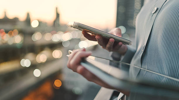 istock modern professional businessman using smartphone and digital tablet outdoors for mobile financial management and investment updates  reviewing trading data on the go with ai-enhanced stock tracking tools 2222688876