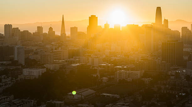 istock Sunlight breaks through skyscrapers. Financial district silhouettes glow during early morning in San Francisco, California. 2222689609