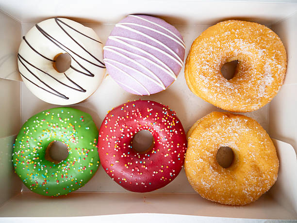 istock Donuts with different colorful icing designs arranged in a box. 2222690599