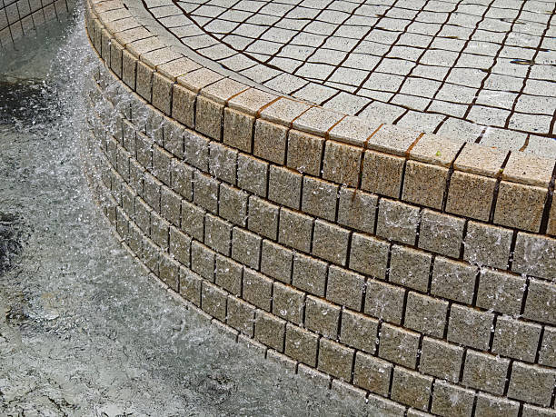 A beautiful fountain in the park is elegantly surrounded by stairs.
