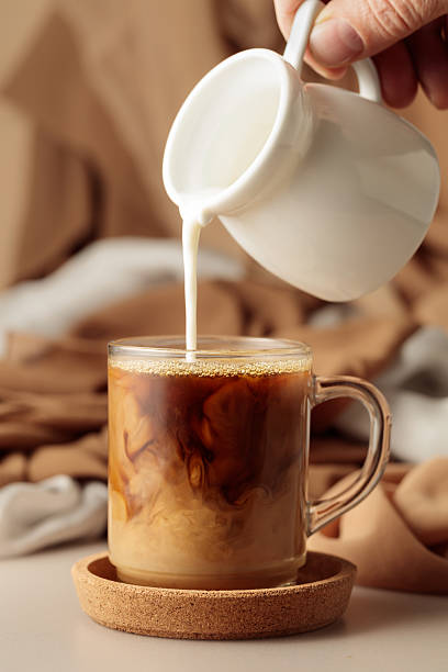 istock Pouring cream in black coffee. 2222700034