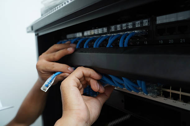 istock A maintenance technician works in a server room with a fiber optic hub 2222701504