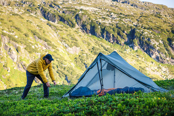 istock Backpacker adjust ultralight tent during trekking and mountain climbing 2222702896