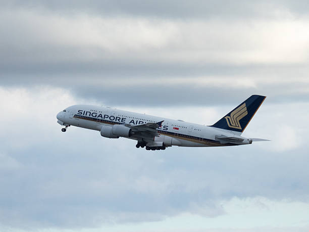 A Singapore Airlines Airbus A380-841 plane, registration 9V-SKN, taking off from Sydney Kingsford Smith Airport as flight SQ222 to Singapore. This image was taken from Mill Stream Lookout, Botany Bay, on a cold, sunny and partly cloudy afternoon on 28 June 2025.