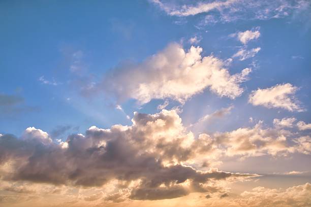 New Zealand sky replacement of a setting sun that is trying to hide behind sone dark clouds.