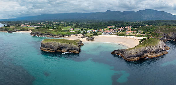 Aerial view of the stunning coastline of Llanes, Spain, featuring turquoise waters, sandy beaches, and rocky islands. Playa de Barro, Barro, Llanes, Asturias, Spain, Southern Europe