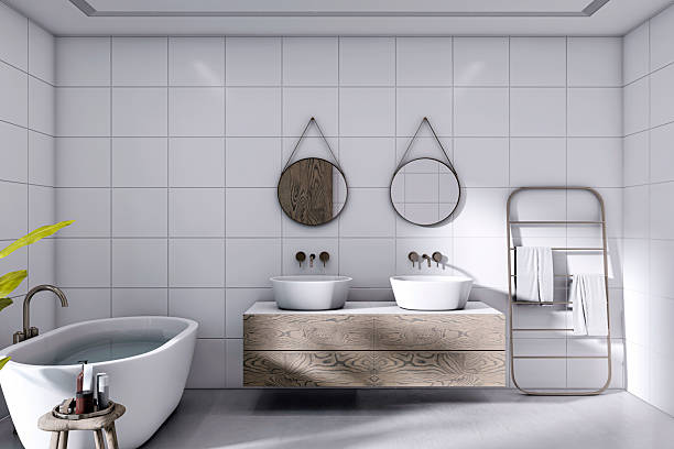 istock Modern minimalist bathroom interior with wooden vanity, twin sinks, round mirrors, and freestanding bathtub in bright tiled environment. 3D Rendering 2222712077
