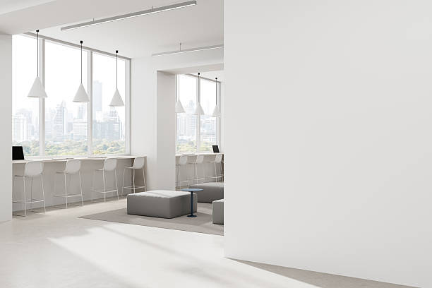 istock Modern office interior with large empty white wall for poster mockup or advertising layout in bright clean design workspace with city view windows. 3D Rendering 2222712286