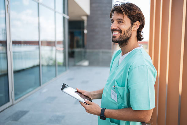 istock Young latin doctor smiling and using a tablet outside the hospital 2222719956