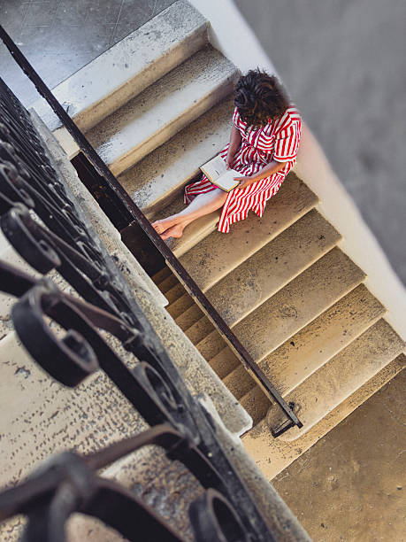istock Woman reading novel while sitting on vintage stone steps 2222724482