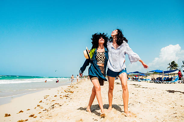 Young friends women walking on the beach