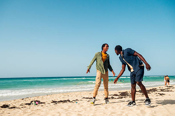 Mixed race African and Asian boy is playing at the outdoor area. smiling happy boy has fun running on the beach. portrait of boy lifestyle with a unique hairstyle.
