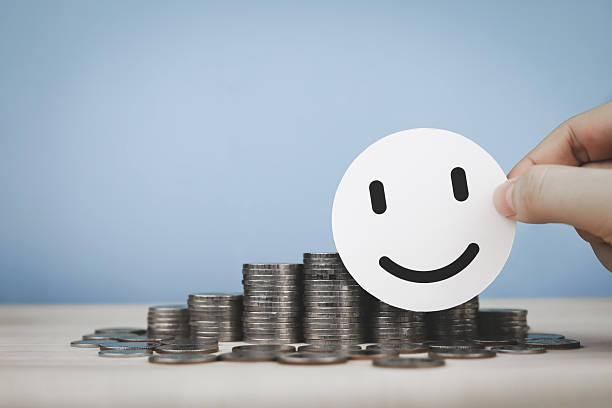 istock Hands placing white circle with smiley face in front stack of coins. Concept of financial status assessment. 2222725738