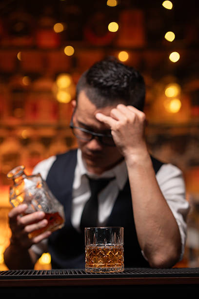istock Handsome businessman or young man sits, drinks whiskey, looks stressed and sad. 2222726206