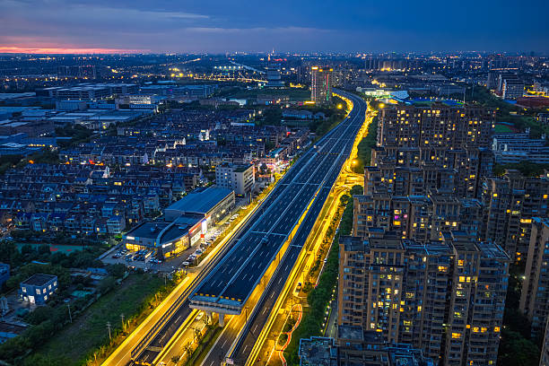 istock Modern elevated expressway illuminated with golden lights cutting through residential and industrial districts at twilight. 2222726315